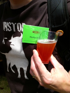 A media pass badge pined to a beer t-shirt